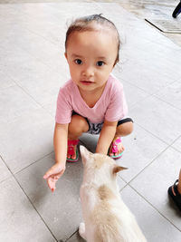 Portrait of cute baby boy on tiled floor