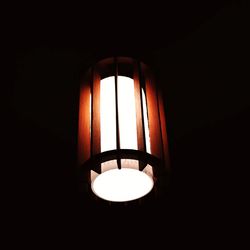 Low angle view of illuminated pendant light in dark room