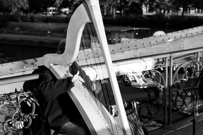 Unrecognizable person playing harp on bridge