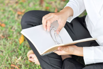 Midsection of couple holding book