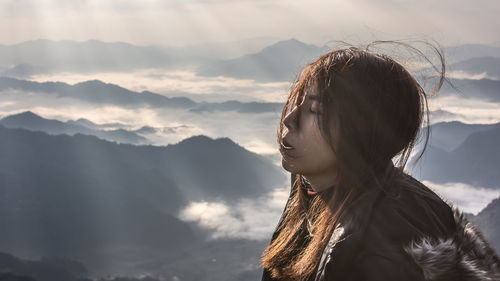 Portrait of woman against mountain range against sky