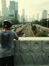 Rear view of man standing on road in city