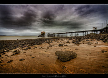 Scenic view of beach against cloudy sky