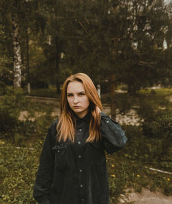 Beautiful young woman standing in forest