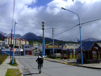 View of dog on road against cloudy sky