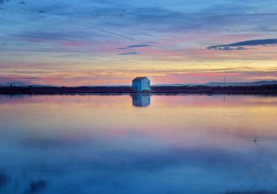 Scenic view of lake against romantic sky at sunset