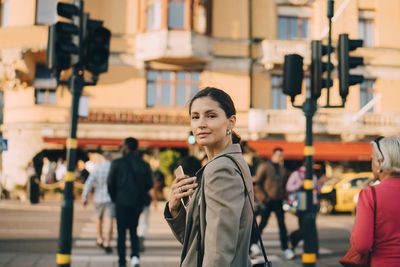 Portrait of confident young woman in city