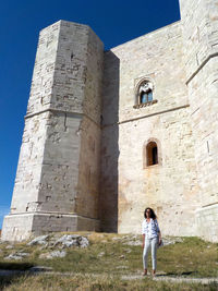 Woman standing by historic building