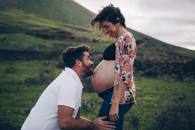 Side view of couple standing on field