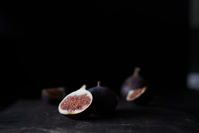 Close-up of fruits on table against black background