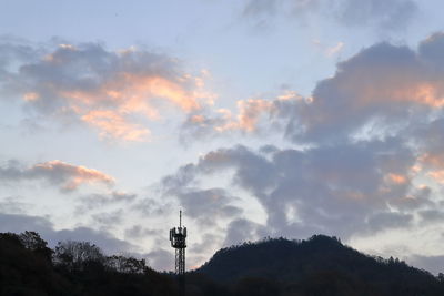 Low angle view of cross on building against sky