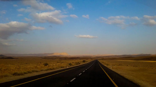 Road passing through landscape against sky