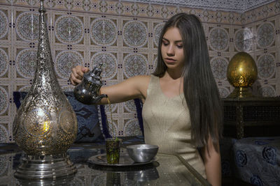 Young woman looking down while sitting on table