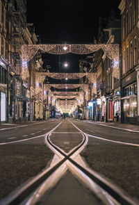 View of illuminated street amidst buildings at night
