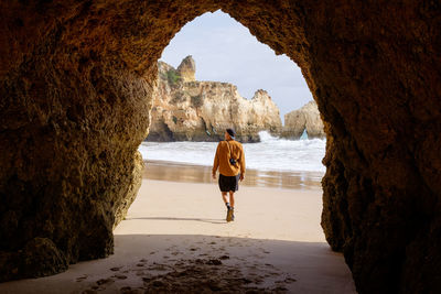 Rear view of woman walking at beach