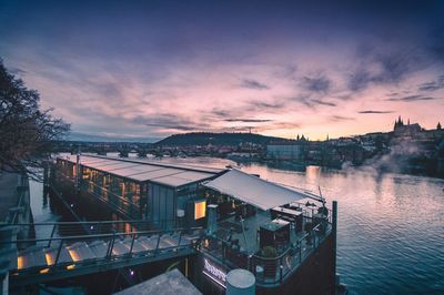 High angle view of river by buildings against sky at sunset