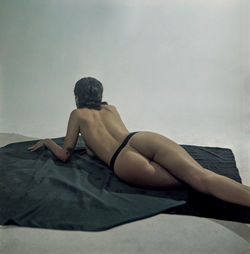 Rear view of woman sitting on bed