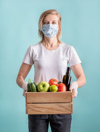 Young woman holding fruits against white background