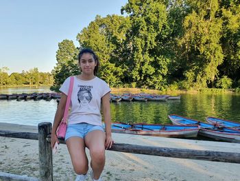Portrait of young woman sitting on boat on lake