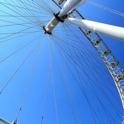 Low angle view of chain swing ride against clear blue sky