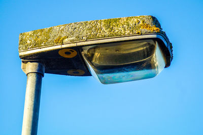 Low angle view of rusty metal against blue sky