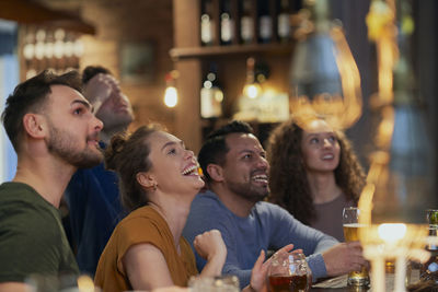 Happy friends watching soccer match at bar