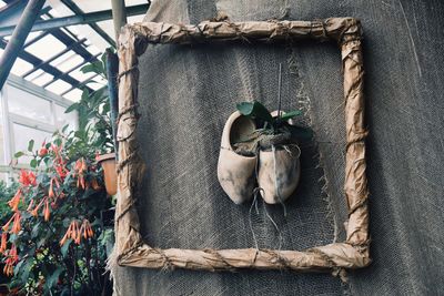 Close-up of flower pots hanging on wood