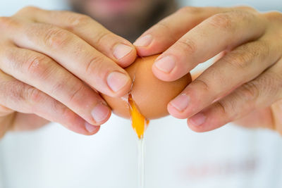 Close-up of man breaking an egg