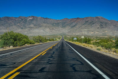 Empty road leading towards mountains