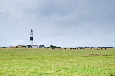 Scenic view of grassy field against cloudy sky