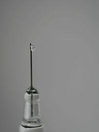 Extreme close-up of syringe against gray background