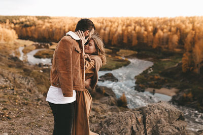 Rear view of couple standing on rock