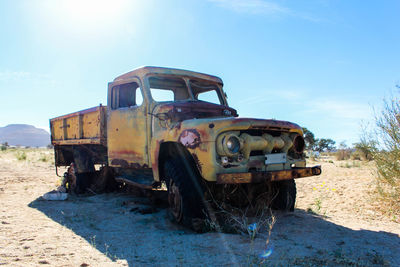 Abandoned truck on field against sky