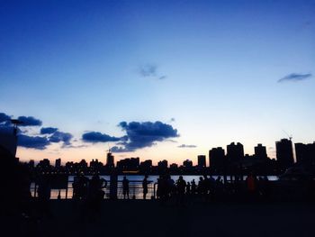 Silhouette buildings against sky at sunset