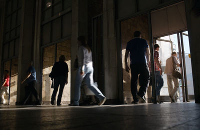 Low angle view of people walking at railroad station