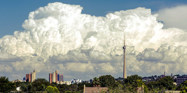 Buildings in city against cloudy sky