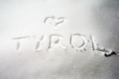 Close-up of text on snow covered land
