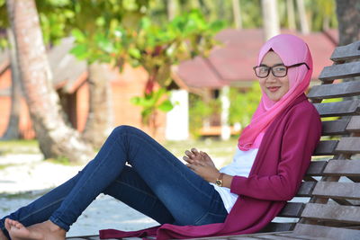 Portrait of smiling young woman sitting outdoors