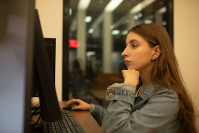 Young woman using computer on table