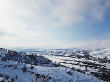 Scenic view of snow covered mountains against sky