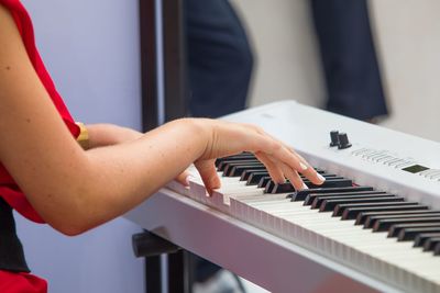 Close-up of hand playing piano