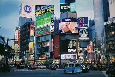 Various advertisements on building in city at night