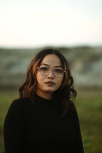 Portrait of young woman standing at beach