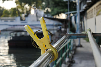 Close-up of yellow metal railing by water