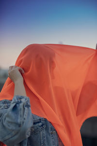 Woman with scarf standing against sky during sunset