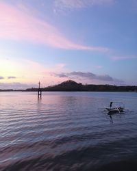 Silhouette people on boat against sky during sunset