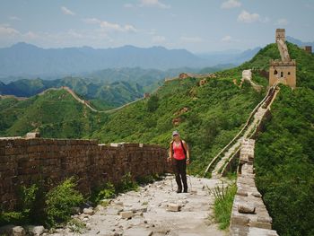 Woman with hiking poles standing at great wall of china