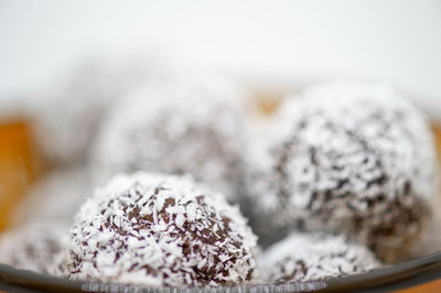 Coconut dessert balls in front of white background