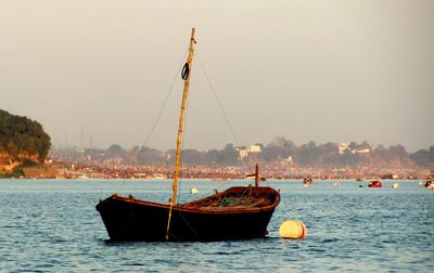 Sailboat moored in sea against clear sky