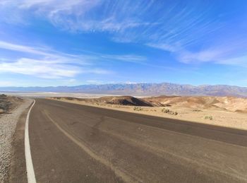 Road amidst desert against sky